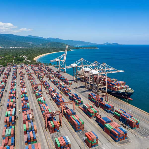 Container ship at Latin American port terminal delivering engineered quartz stone from China