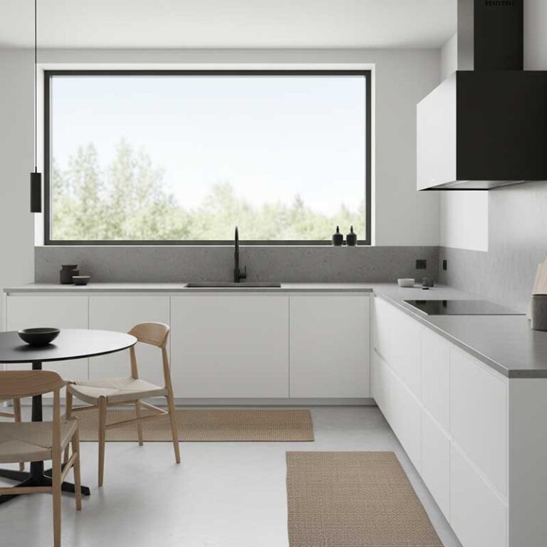 Modern minimalist Scandinavian kitchen with grey concrete-look matte engineered quartz stone countertop and handleless white cabinets