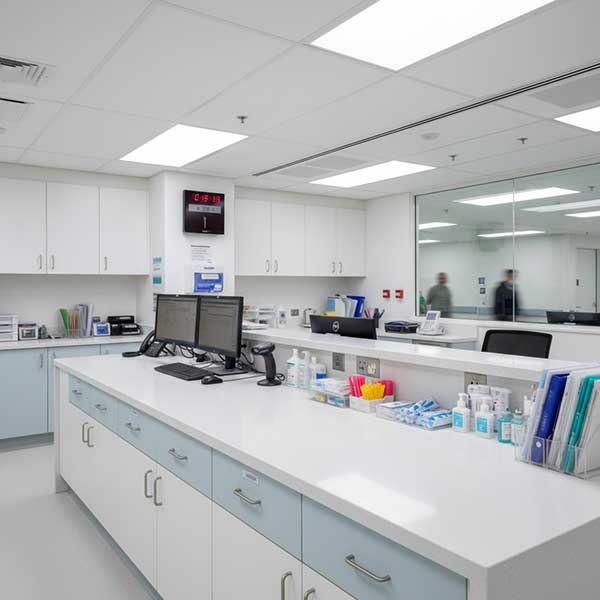 Modern healthcare facility nurses station featuring white engineered quartz stone countertop surface in sterile environment