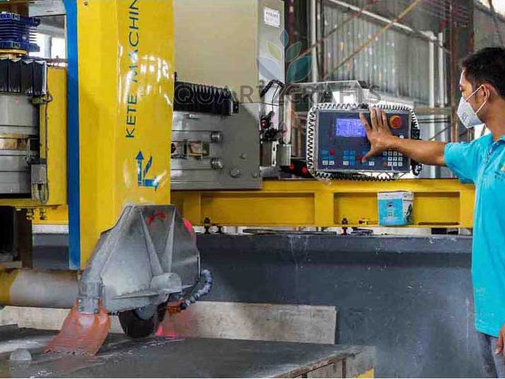 Factory technician operating advanced machinery to cut quartz slabs, ensuring tight dimensional tolerances for B2B clients