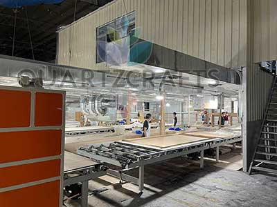 Skilled worker carefully spreading raw quartz materials to maintain strict color consistency across production batches